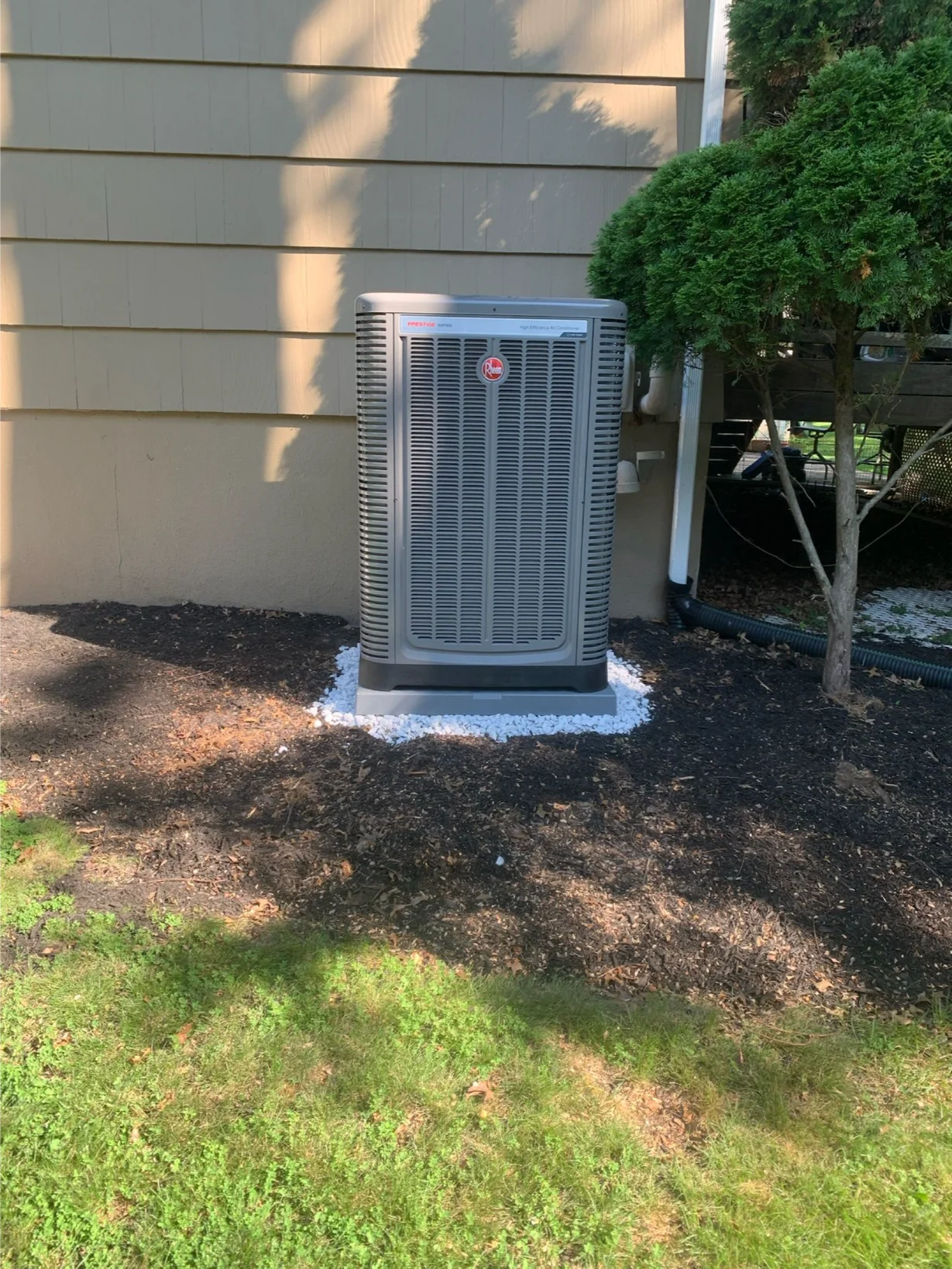 outdoor Rheem AC unit newly installed next to a house